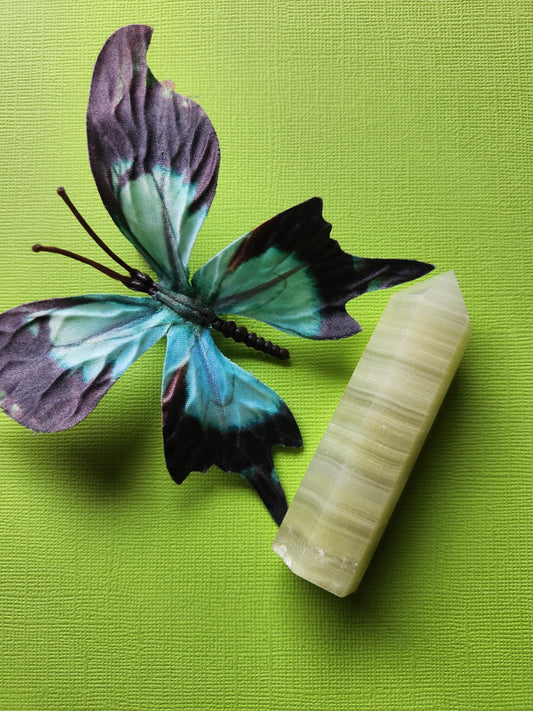 Afghan Jade Tower standing upright on a bright green background, showcasing its smooth, polished surface and natural green hues. This healing crystal point is ideal for meditation, chakra balancing, and spiritual decor. The tower’s unique natural patterns highlight the beauty of authentic Afghan Jade, perfect for energy work and enhancing calmness and balance in any space.