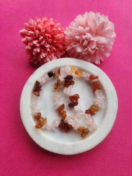 Rose Quartz and Carnelian chip bracelet featuring natural pink rose quartz and vibrant orange carnelian crystal chips on one stretchy bracelet, handmade mixed crystal chip bracelet, love and confidence crystal jewelry, heart chakra and sacral chakra bracelet, emotional healing gemstone bracelet, feminine boho crystal bracelet, rose quartz carnelian bracelet for gifting photographed close up