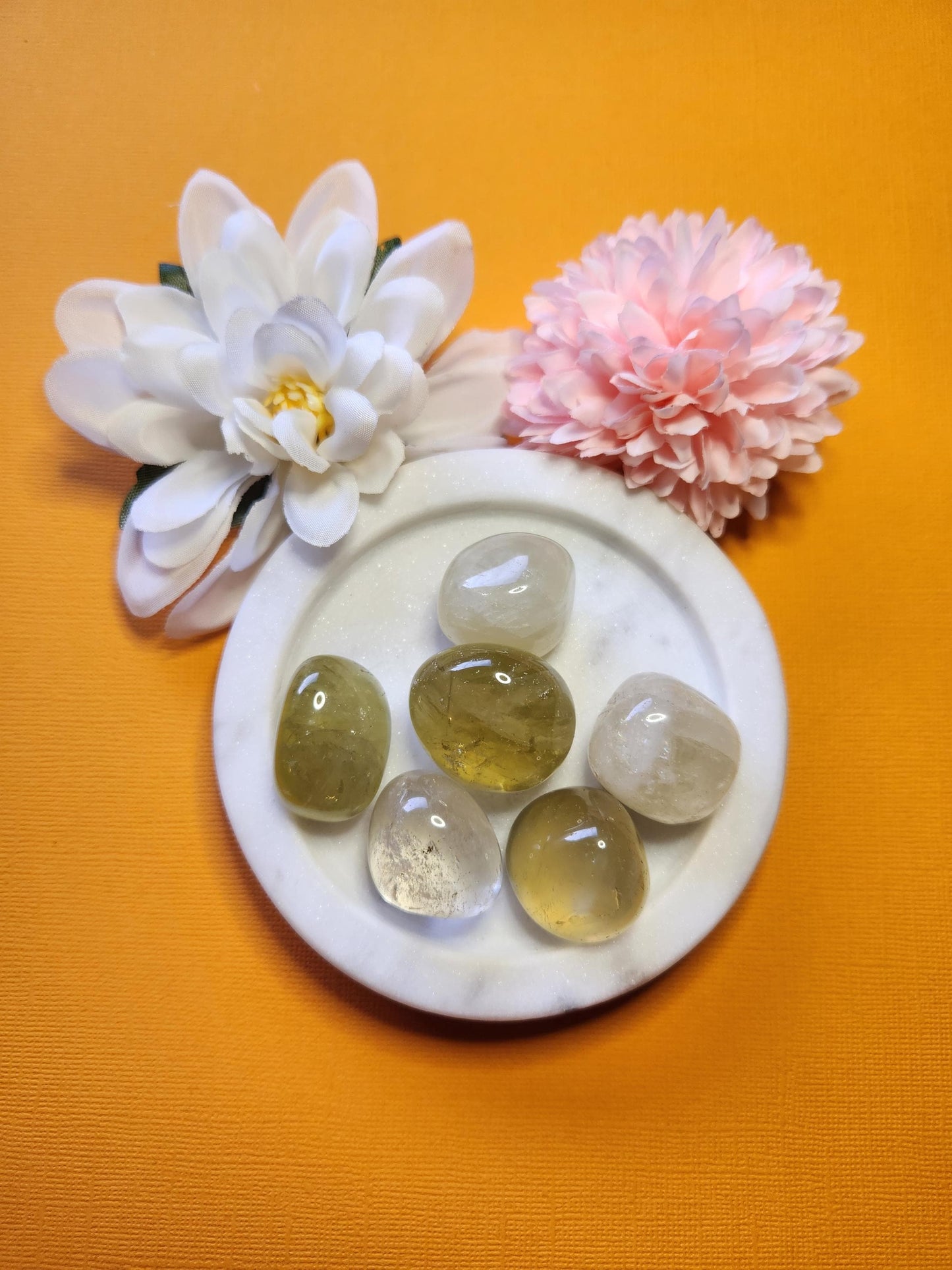 Bright yellow Heat Treated Citrine tumble stones displayed on a yellow background, highlighting their vibrant color and polished surfaces. These natural crystal chips are known for attracting abundance, prosperity, and positive energy. Ideal for chakra healing, jewelry making, and crystal collections. The yellow backdrop enhances the warm, sunny tones of the citrine tumblers, emphasizing their smooth texture and radiant glow.