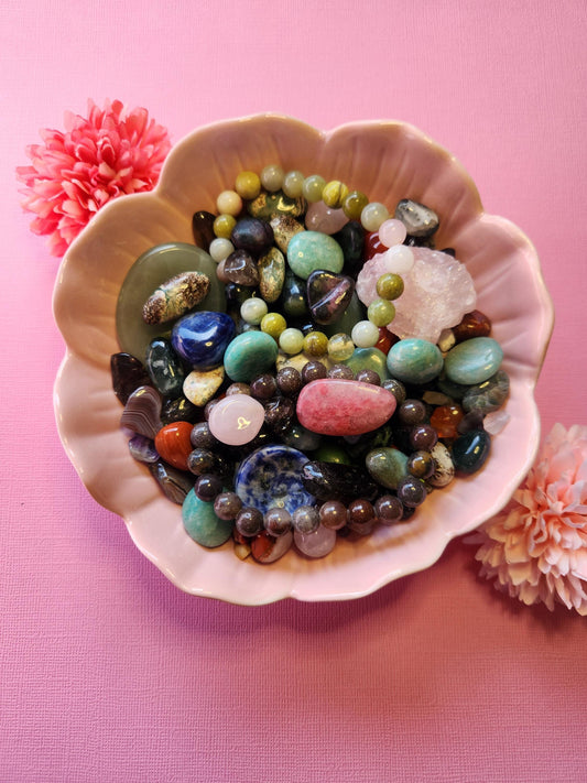 Crystal Confetti on a pink background, showcasing a vibrant mix of tumbled stones, crystal chips, and raw gemstones. This 1/4 cup scoop features colorful crystals such as Amethyst, Quartz, Rose Quartz, and more. Ideal for crystal lovers, spiritual gifts, or witchy surprise sets. The photo highlights the variety and sparkle of the confetti mix, perfect for manifestation, altars, or metaphysical crafting.