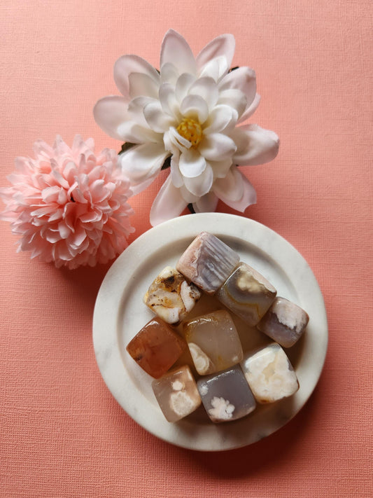 Beautiful natural Flower Agate cubes displayed on a soft pink background, featuring polished healing crystals with unique floral and dendritic patterns. These Flower Agate gemstones are perfect for crystal collectors, meditation, chakra balancing, stress relief, spiritual healing, and metaphysical uses. Ideal for gifting, home decor, energy work, grounding, and enhancing mindfulness practices.