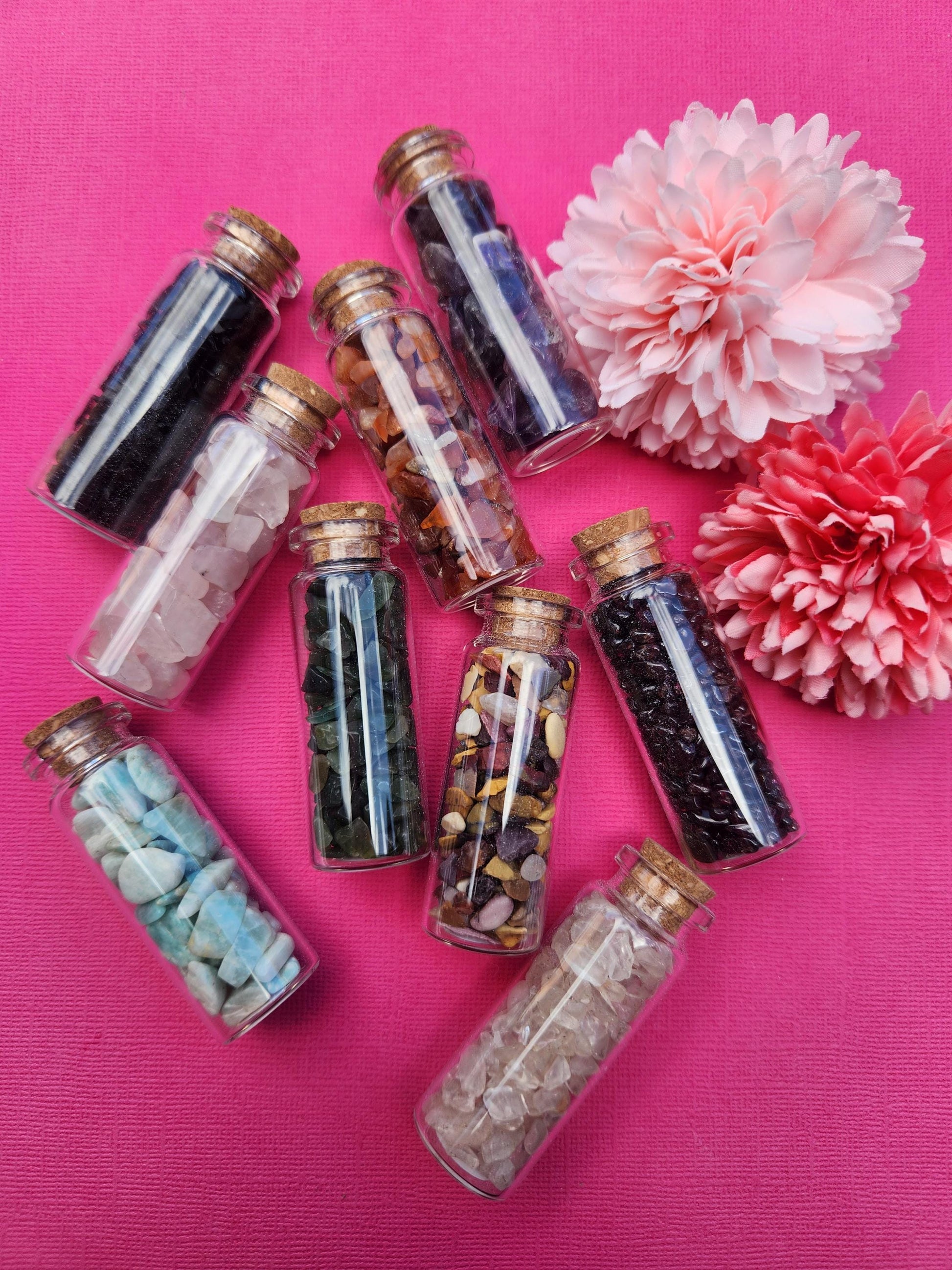 Main photo showing 9 assorted crystal chip wish bottles featuring mixed gemstones, mini glass bottles filled with natural crystal chips, gemstone wish bottles for manifestation and intention setting, crystal chip bottles for gifting altar decor and spiritual use, mixed healing crystals photographed together close up