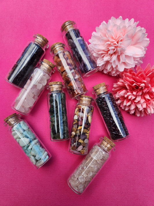 Main photo showing 9 assorted crystal chip wish bottles featuring mixed gemstones, mini glass bottles filled with natural crystal chips, gemstone wish bottles for manifestation and intention setting, crystal chip bottles for gifting altar decor and spiritual use, mixed healing crystals photographed together close up