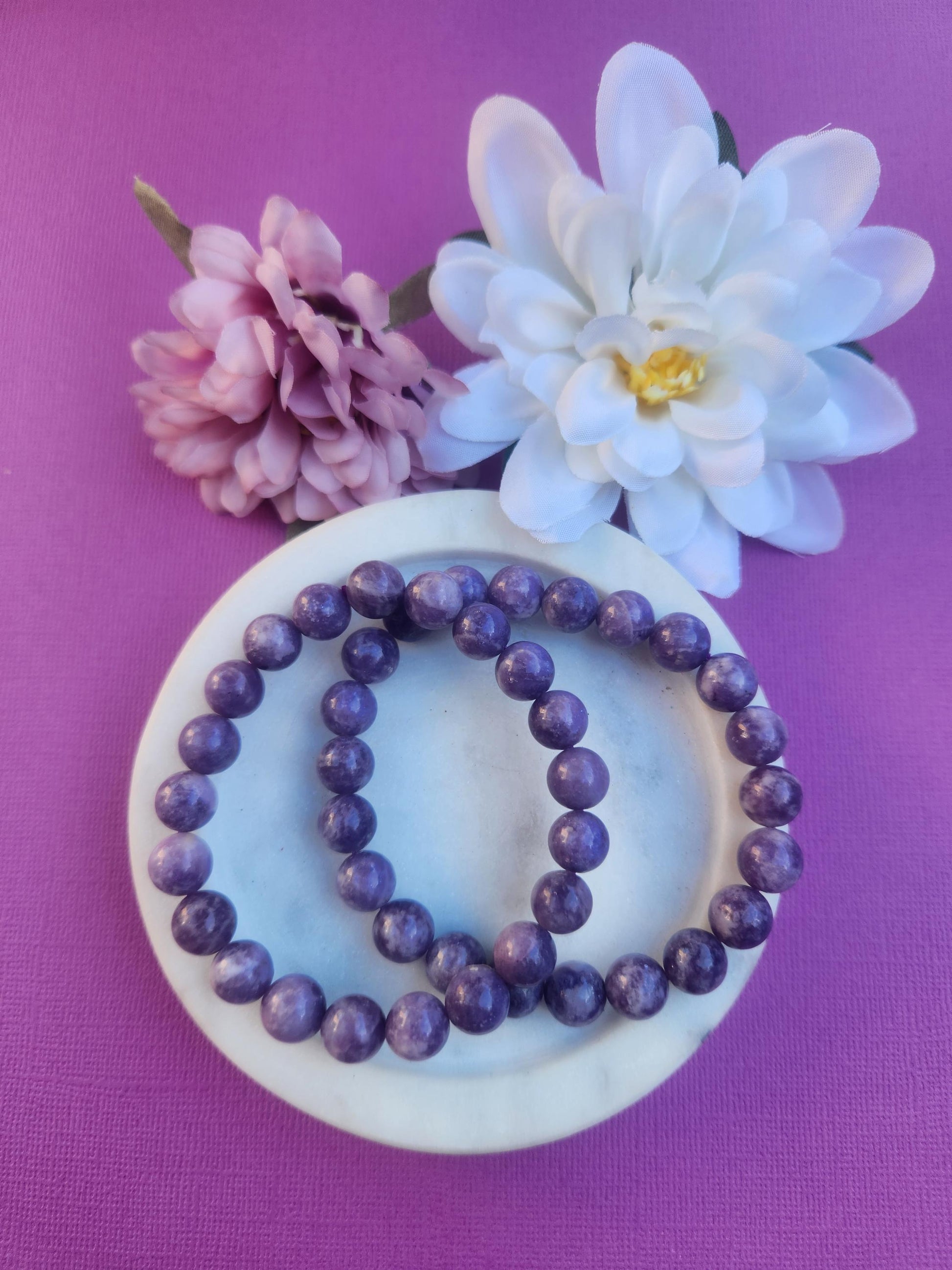 Lepidolite 8mm Beaded Bracelet featuring natural purple Lepidolite gemstone beads on a comfortable stretch bracelet. Beautiful crystal jewellery associated with calm, balance, stress relief, emotional wellbeing, mindfulness, meditation, and peaceful energy. Perfect for everyday wear, stacking with other crystal bracelets, gifting, spiritual practices, crystal collections, and self care. Natural Lepidolite bracelet with soft lilac and purple tones.