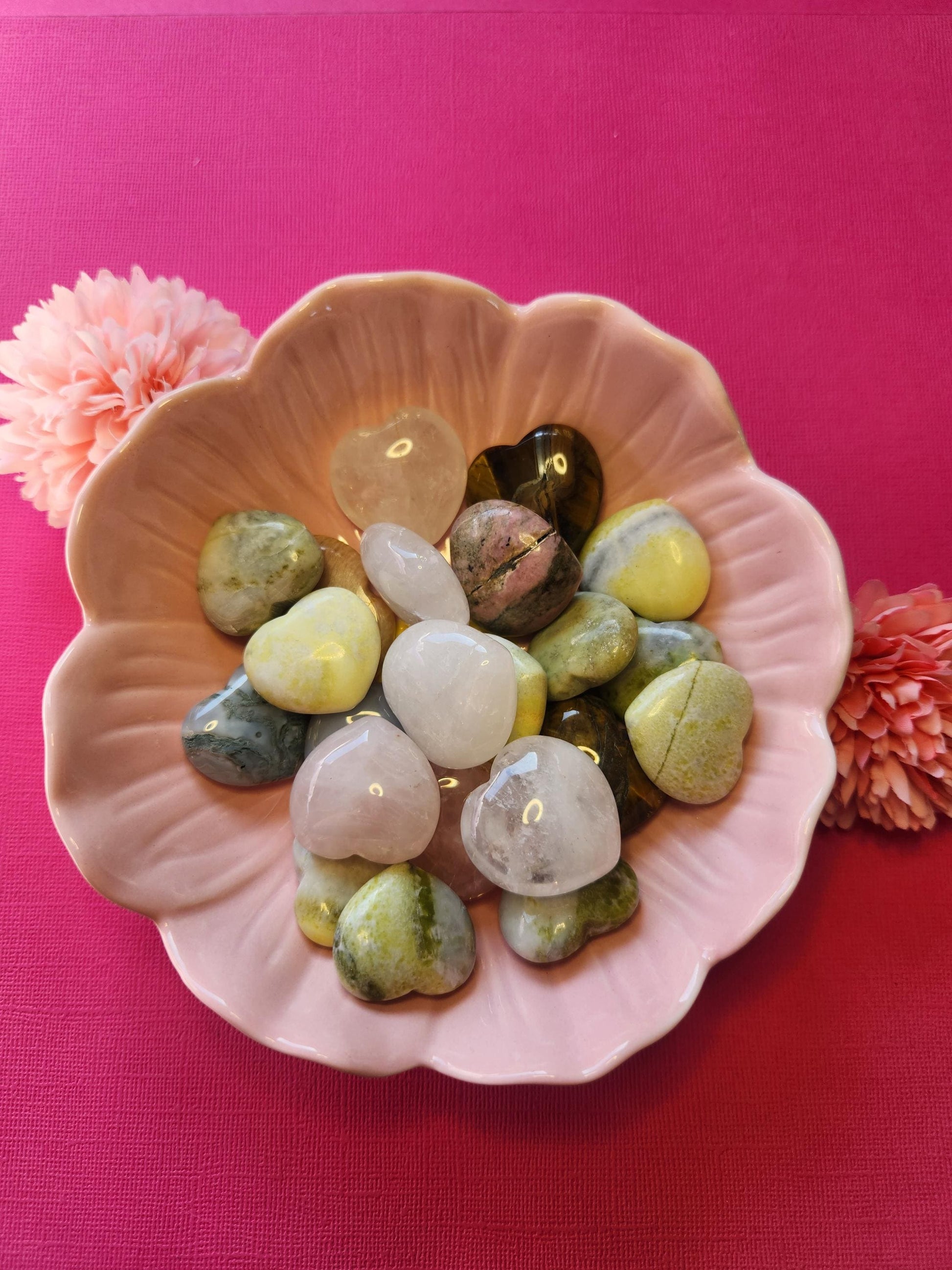 Assorted mystery crystal hearts displayed on a pink background, featuring a variety of polished gemstone hearts like rose quartz, amethyst, clear quartz, and more. Each heart is intuitively chosen to bring unique healing properties such as love, protection, clarity, and energy balance. Perfect as a surprise gift, pocket stone, or witchy decor. Great for crystal collectors, meditation, and spiritual healing.