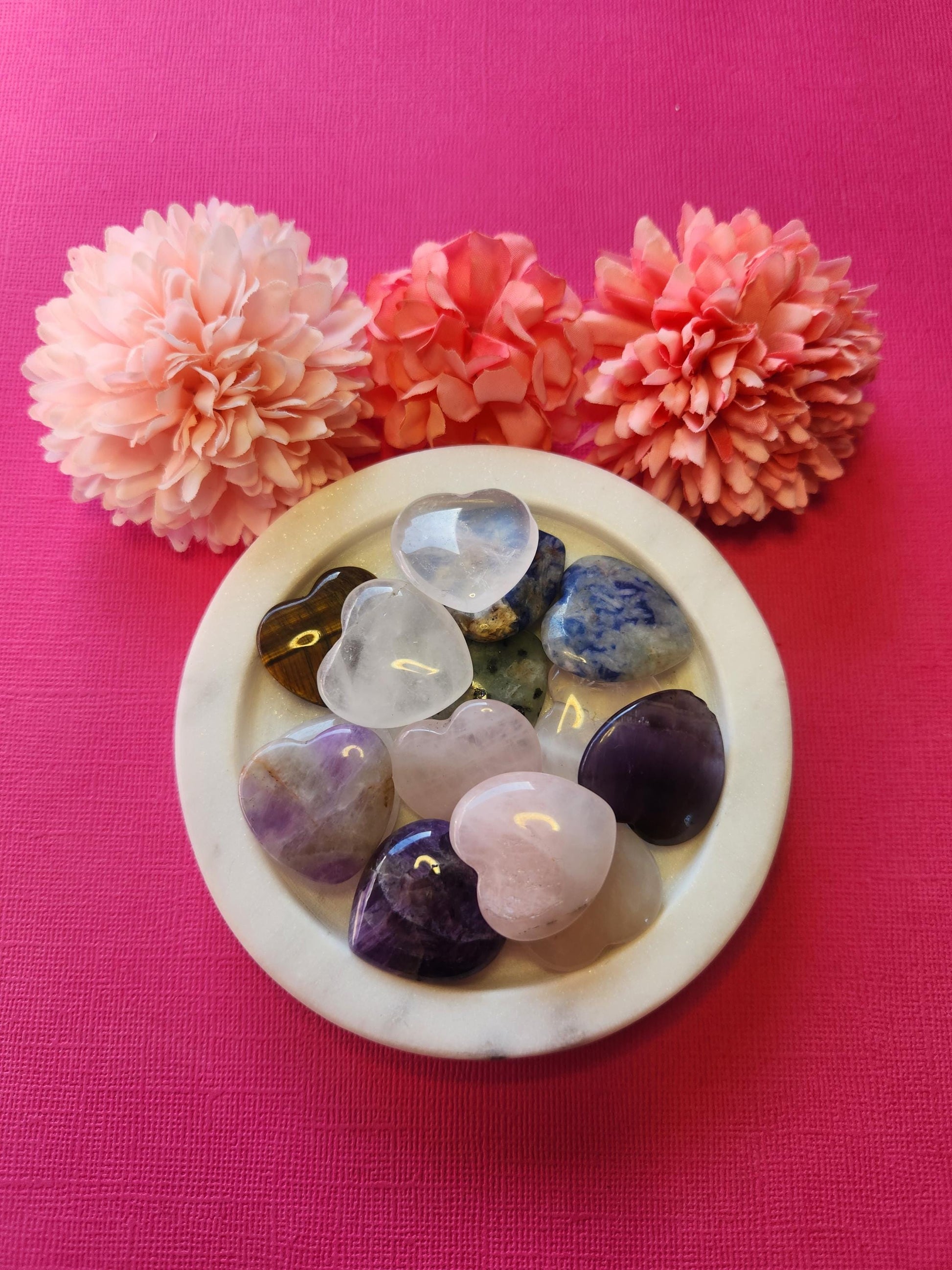 Small mystery crystal hearts displayed on a pink background, featuring a variety of polished mini gemstone hearts like rose quartz, amethyst, clear quartz, and more. Each small heart is intuitively chosen to bring unique healing properties such as love, protection, clarity, and energy balance. Perfect as a surprise gift, pocket stone, or witchy decor. Ideal for crystal collectors, meditation, and spiritual healing.