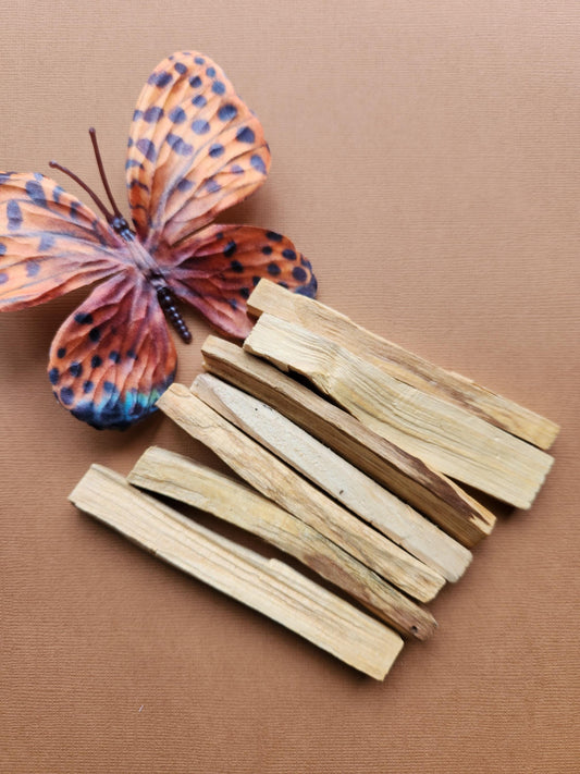 Palo Santo sticks displayed on a warm brown background, showcasing their natural wood texture and earthy tones. These sacred wood sticks are traditionally used for smudging, energy clearing, meditation, and spiritual rituals. The rich brown backdrop complements the organic, rustic appearance of the Palo Santo, emphasizing its grounding and cleansing properties. Perfect for holistic wellness, spiritual practices, and natural incense lovers.
