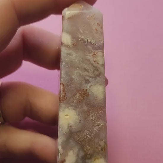 Video of a person showcasing a Pink Amethyst tower on a light pink background. Features a polished, pointed crystal tower in soft pink hues, perfect for crystal collectors, healing, meditation, and spiritual décor.