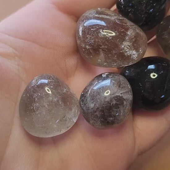 Video showcasing polished Smoky Quartz tumbles on a brown background. Features smooth, translucent brown stones perfect for crystal collectors, healing, meditation, and spiritual décor.
