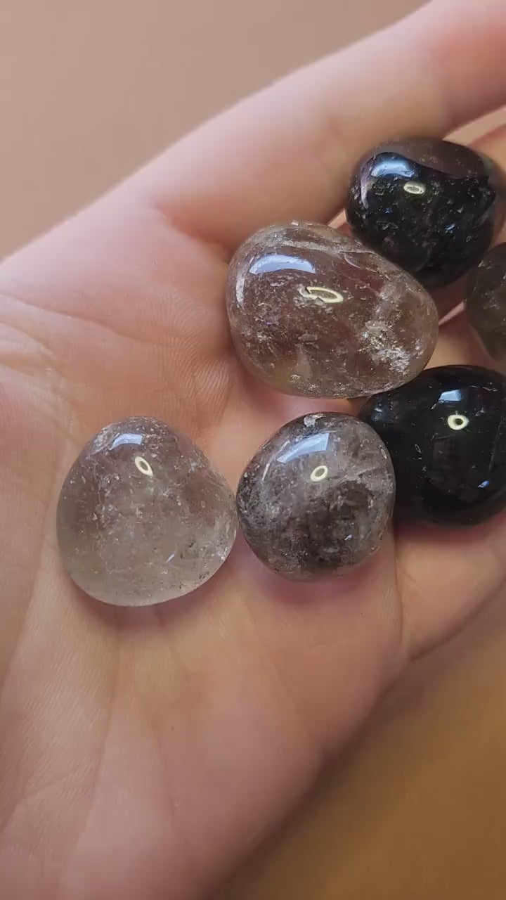 Video showcasing polished Smoky Quartz tumbles on a brown background. Features smooth, translucent brown stones perfect for crystal collectors, healing, meditation, and spiritual décor.