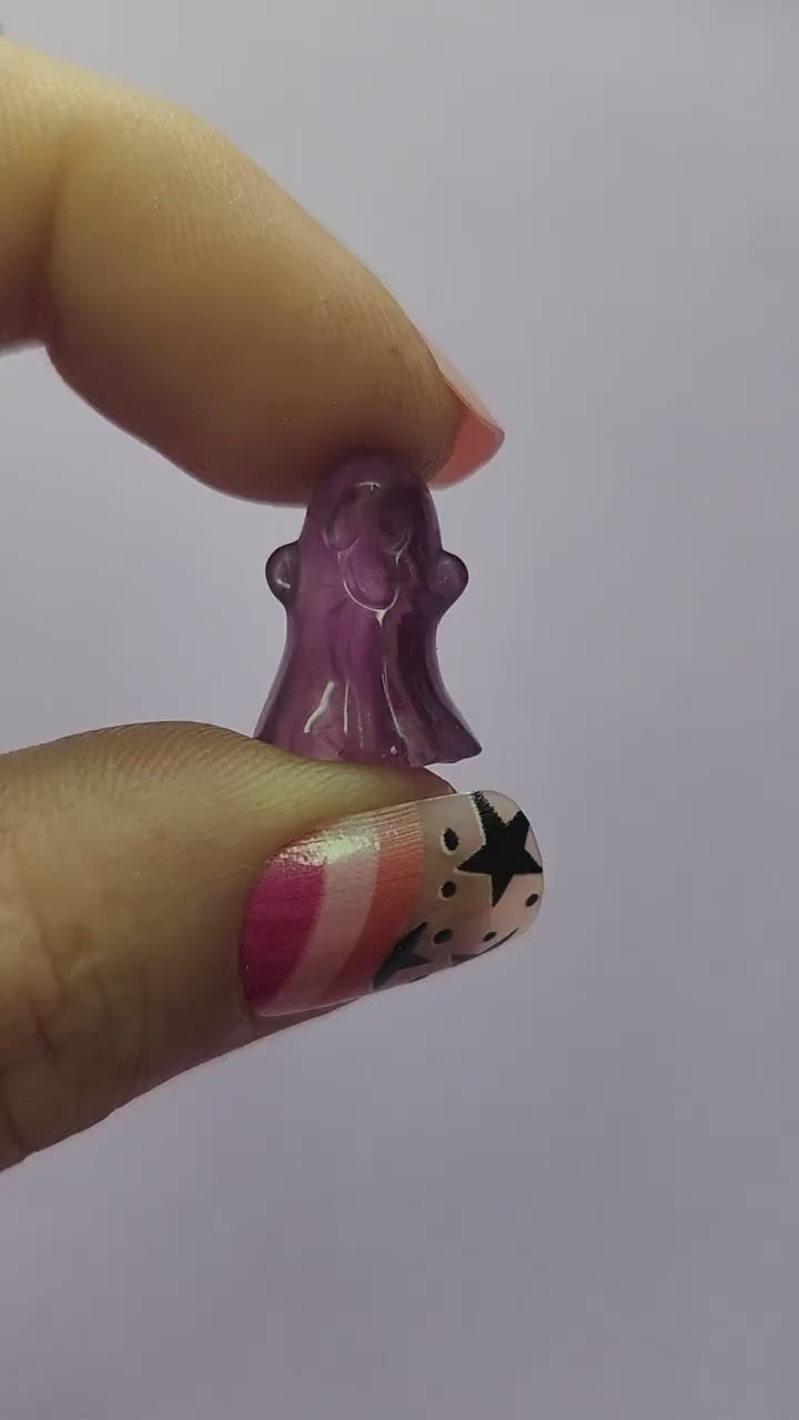 Close-up video of a single fluorite mini ghost carving held in hand, showcasing polished details and natural purple, green and blue fluorite banding against a lavender backdrop. Perfect for fluorite carvings, mini crystal ghosts, and collectible gemstone figures