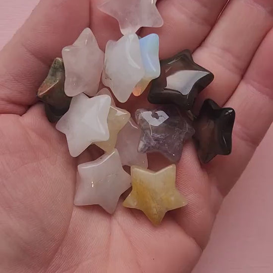 Close-up video of a hand holding an intuitively chosen mini crystal star against a light pink background. Each tiny gemstone star (approx. 2cm wide x 5mm thick) is polished from natural crystals such as Amethyst, Rose Quartz, Green Aventurine, Obsidian, and more. Perfect for altar décor, crystal grids, moon rituals, pocket talismans, manifestation work, spiritual guidance, and as a thoughtful gift for crystal lovers.