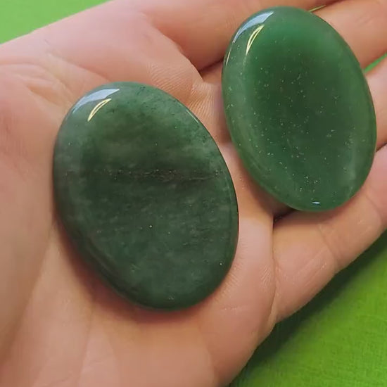Polished Green Aventurine worry stone held in hand against a green background. Smooth palm-sized crystal for anxiety relief, luck, prosperity, heart chakra healing, meditation, and mindfulness. Perfect for crystal collectors, spiritual practice, or gifting.