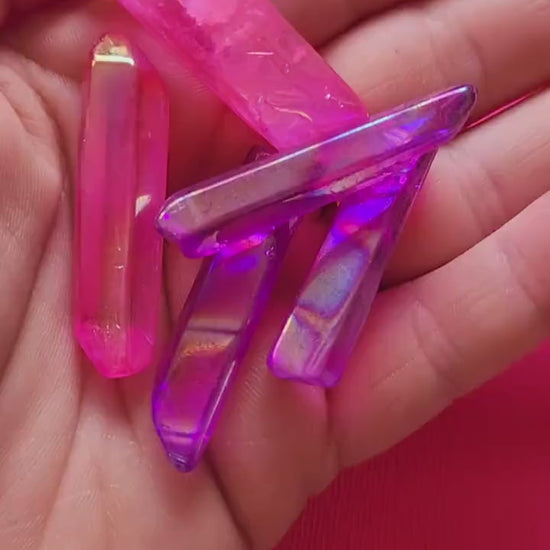 Video showcasing Aura Quartz rough points in pink and purple on a pink background. Features natural crystal points with vibrant iridescent hues, perfect for crystal collectors, healing, meditation, and spiritual décor