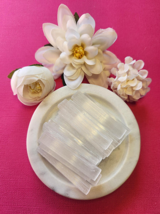 Selenite sticks displayed on a bright pink background, highlighting their smooth, white, translucent appearance. These natural crystal wands are commonly used for energy cleansing, aura clearing, and spiritual protection. Ideal for Reiki, meditation, and charging other crystals. The vibrant pink backdrop contrasts beautifully with the calming, high-vibration energy of the selenite, making it perfect for healers and crystal collectors.
