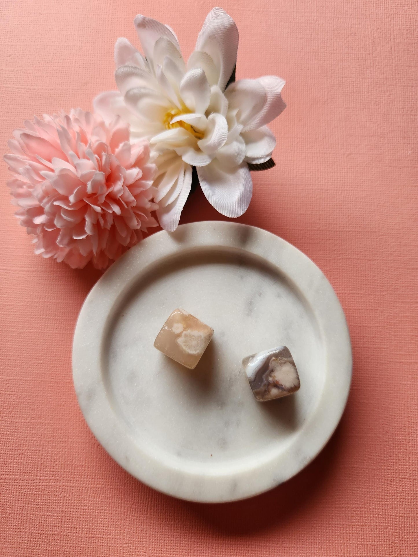 Set of small polished Flower Agate cubes shown on a pink background. Each cube displays natural floral patterns unique to Flower Agate crystals. These healing stones are great for meditation, energy balancing, chakra healing, spiritual wellness, grounding, calming anxiety, and adding natural beauty to your crystal collection or altar. Perfect for gifting or personal metaphysical use.